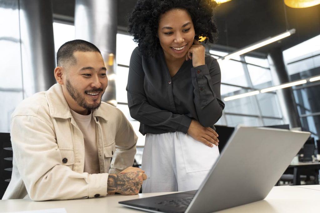 Duas pessoas analisando informações em um laptop